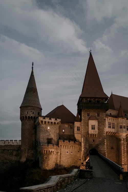 Facade of majestic ancient stone Corvin Castle in Gothic Renaissance style located beneath overcast dramatic sky in Romania