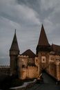 Facade of majestic ancient stone Corvin Castle in Gothic Renaissance style located beneath overcast dramatic sky in Romania