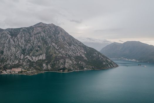 在多云的天空下，平静的蓝色海水映衬着黑山沿海山脉的壮丽景色