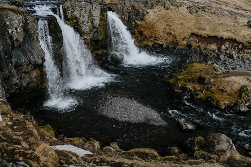 бесплатная Водопад на коричневой скалистой горе Стоковое фото