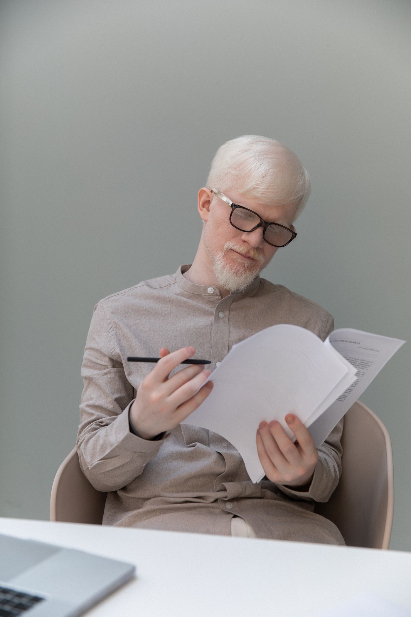 Un homme à lunettes examine des documents à son bureau