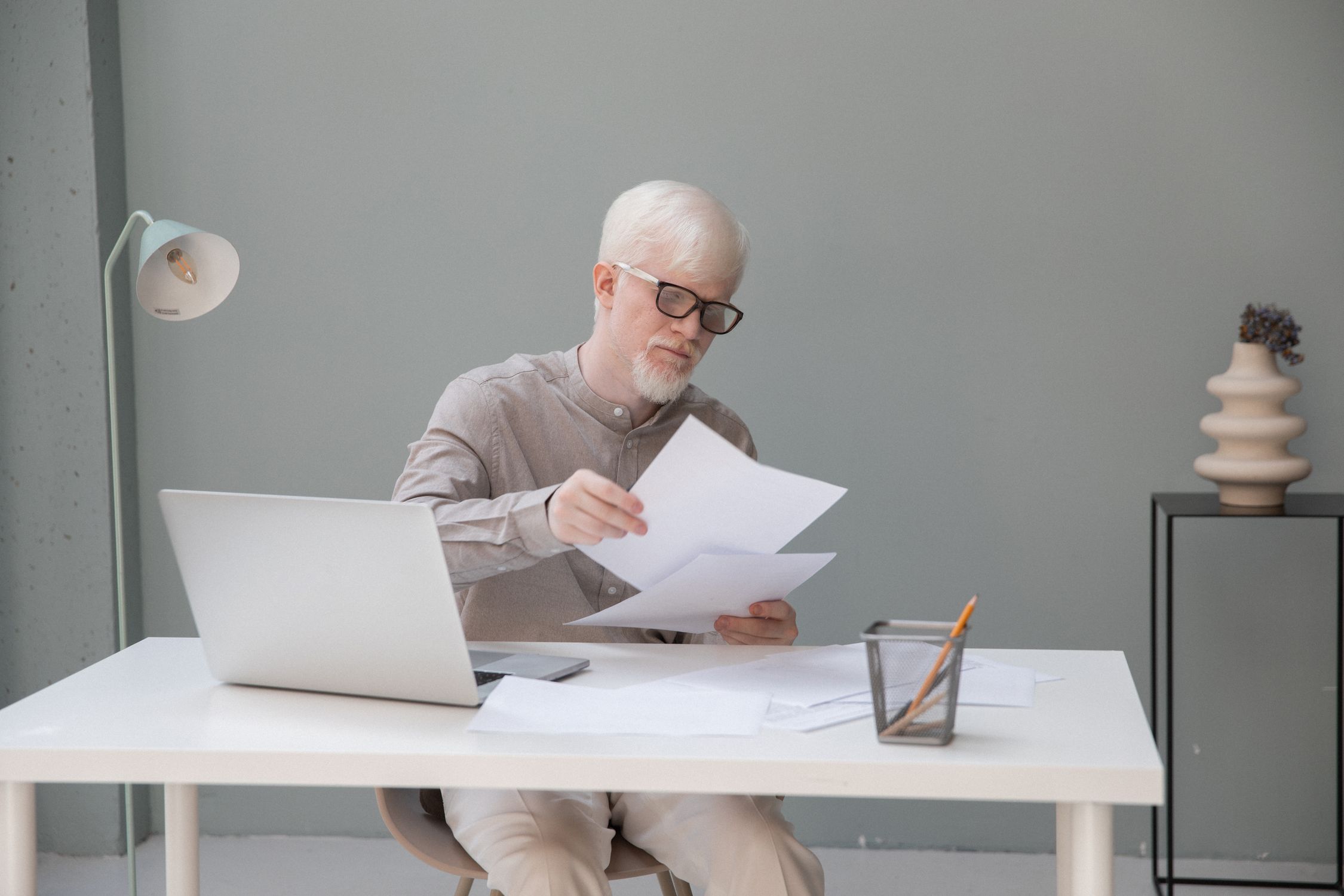Male manager with papers near laptop in office · Free Stock Photo