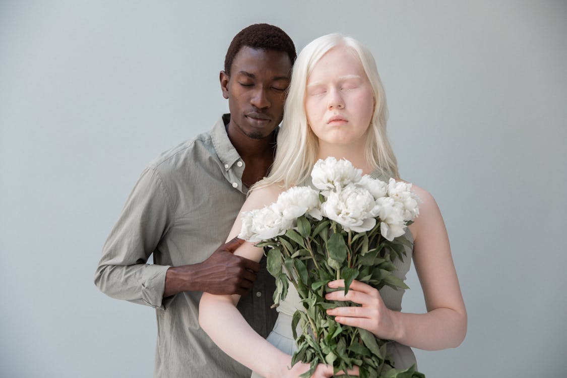 Albino and black couple with flowers · Free Stock Photo