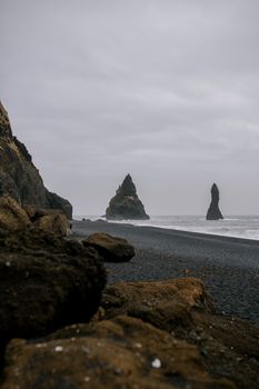 在阴云密布的天空下，冰岛埃斯菲贾拉海滩的花岗岩海堆景色令人惊叹，蔚为壮观