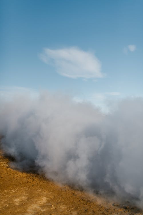 Dense smoke on dry terrain under blue sky