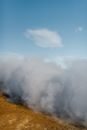 Dense smoke on dry terrain under blue sky