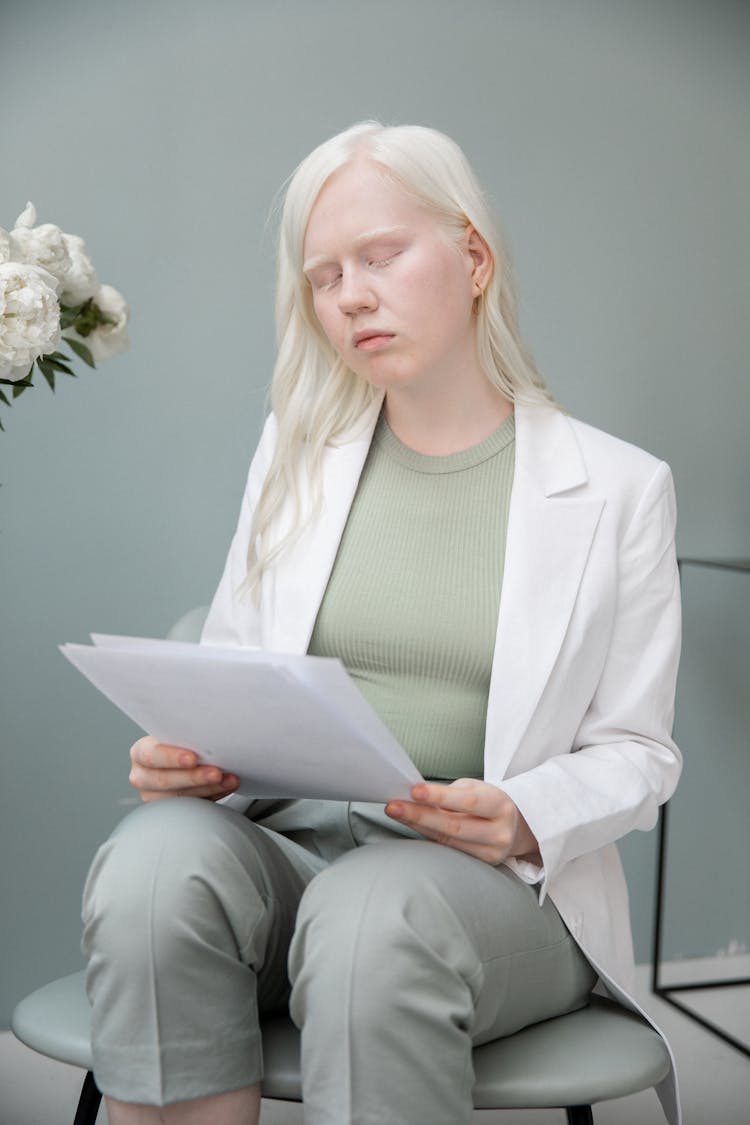 Albino Woman Reading Documents In Room