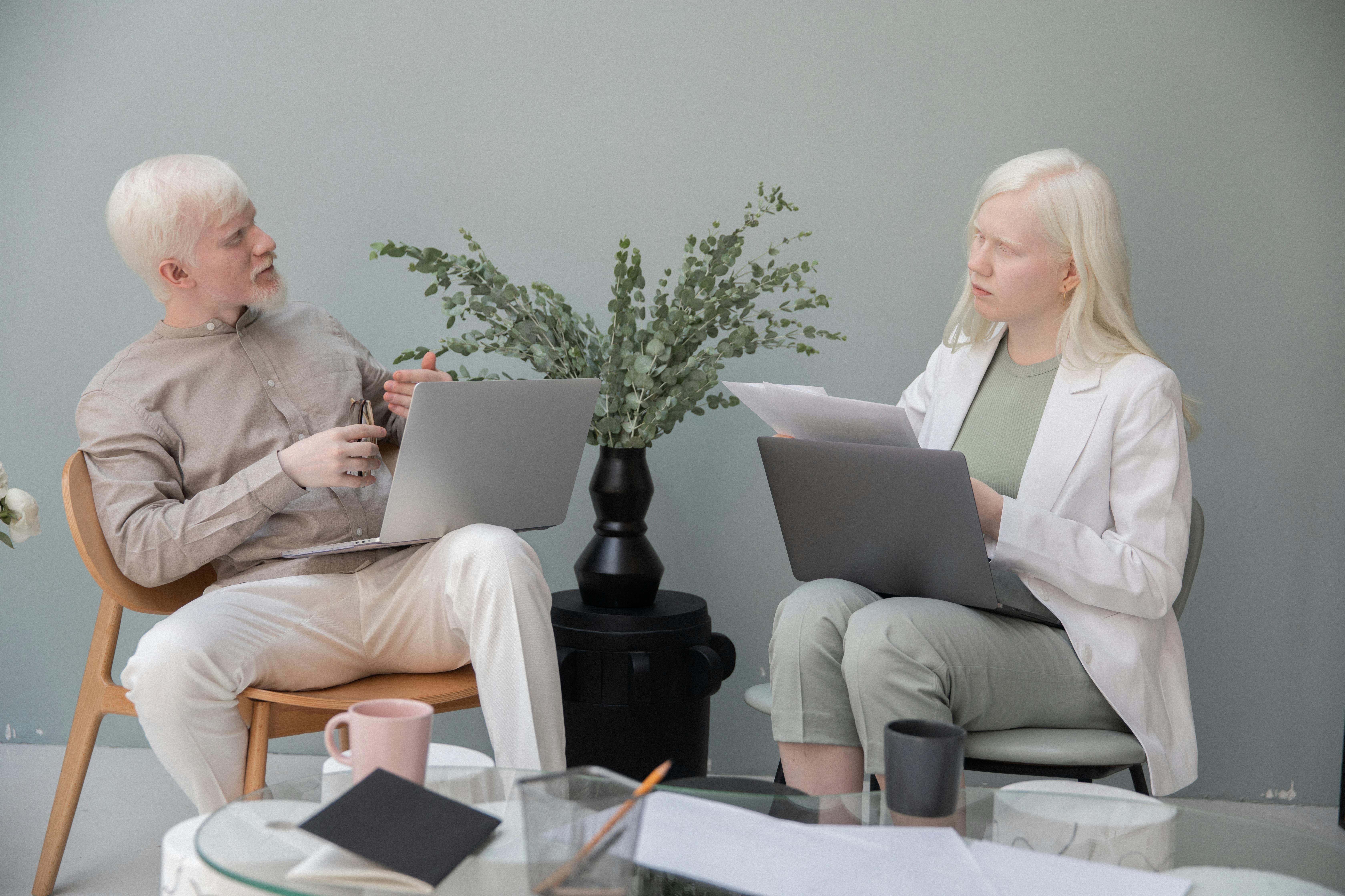 focused albino colleagues working on laptop