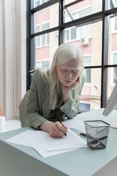 Focused businesswoman reviewing documents in a modern office setting.