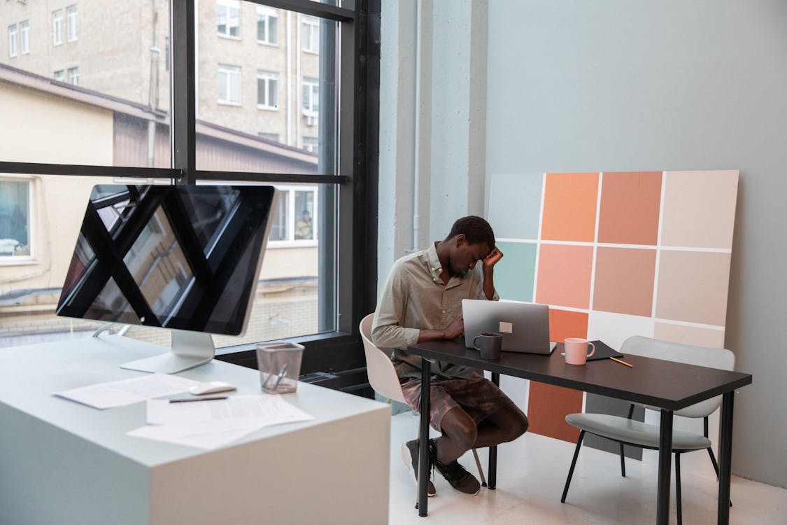 Tired black businessman in modern office