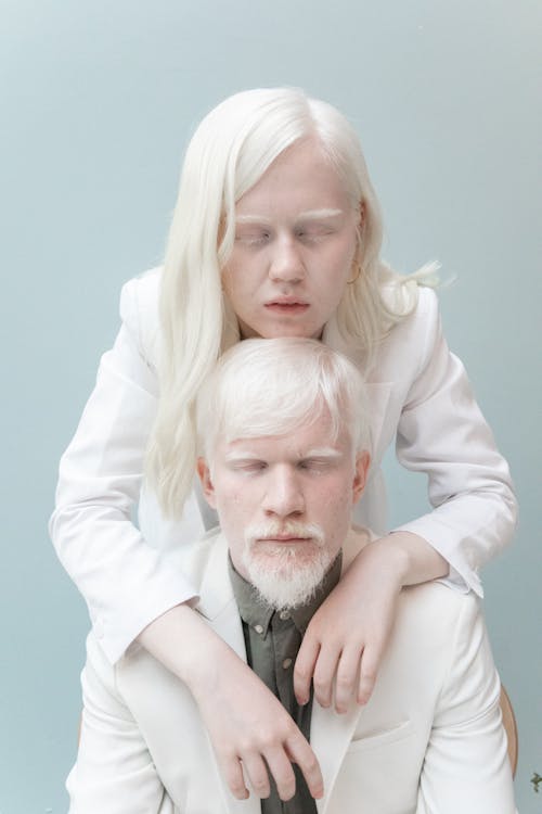 пара альбинос, обнимающаяся на сером фоне