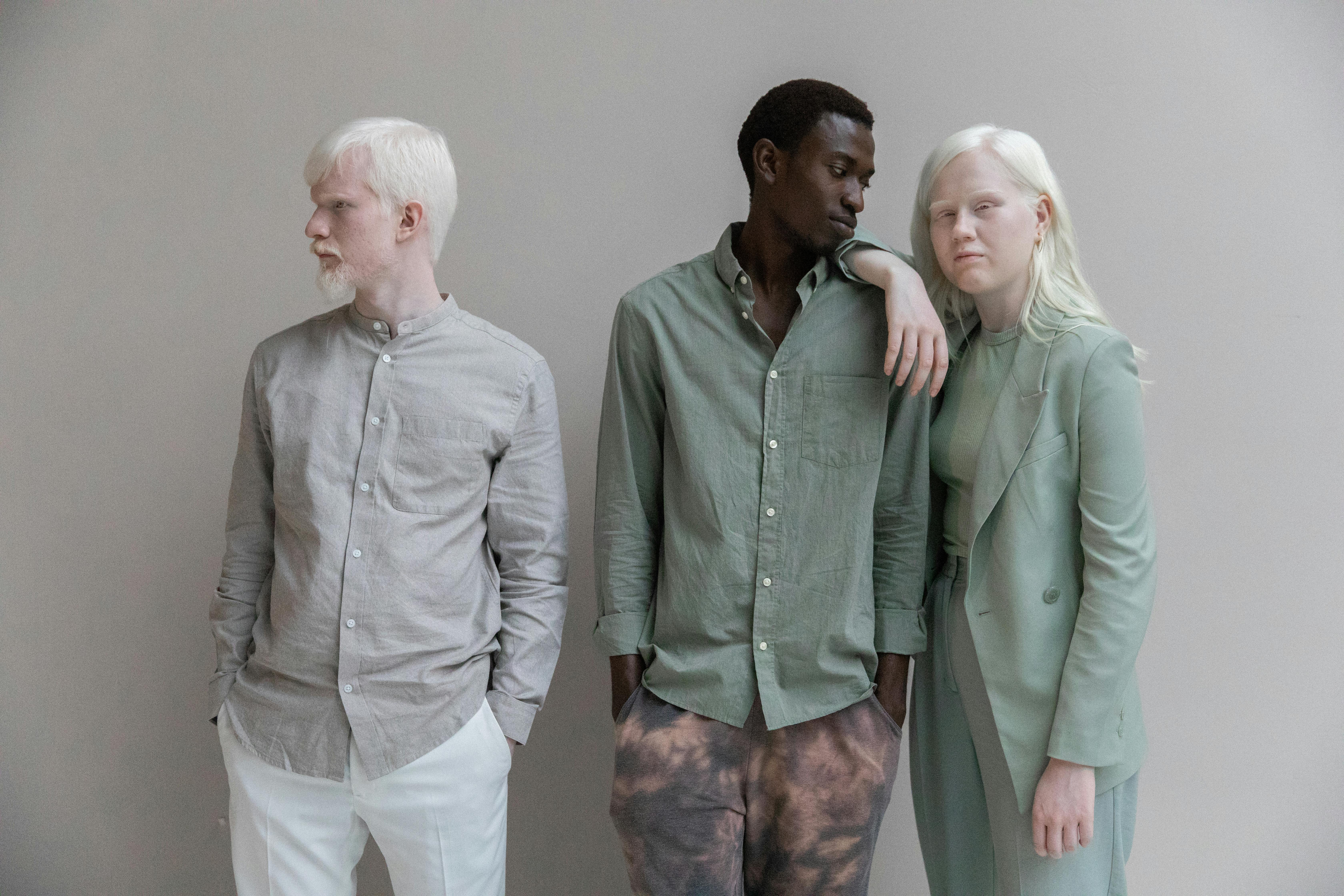 Group of charismatic multiracial models in stylish outfits standing close in modern studio