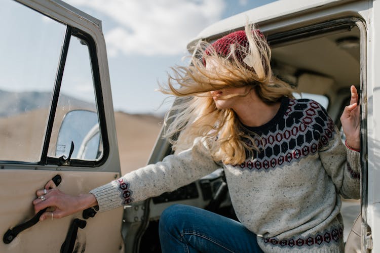 Woman In Grey Sweater Riding A Car