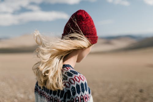 Shallow Focus of a Woman Wearing Red Beanie and Knitted Sweater