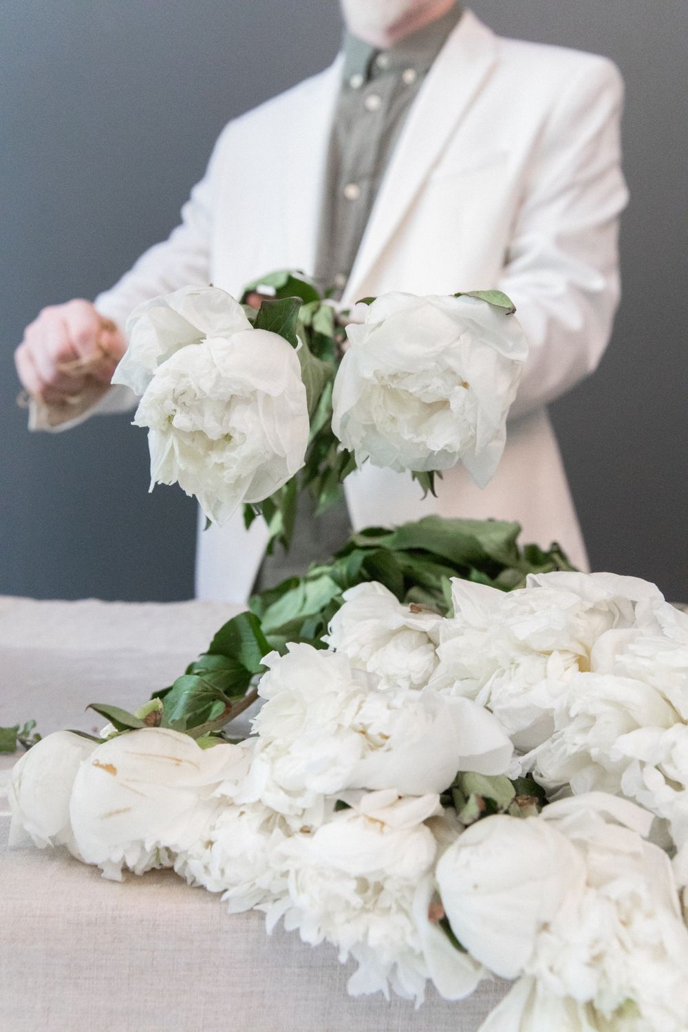 Florist carefully arranging white peonies