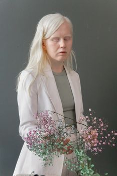 一位手持粉彩花的女性肖像，散发着优雅与宁静的室内氛围