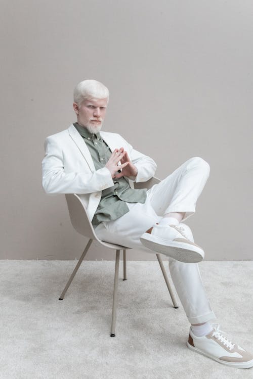 Man in White Suit Sitting on White Chair