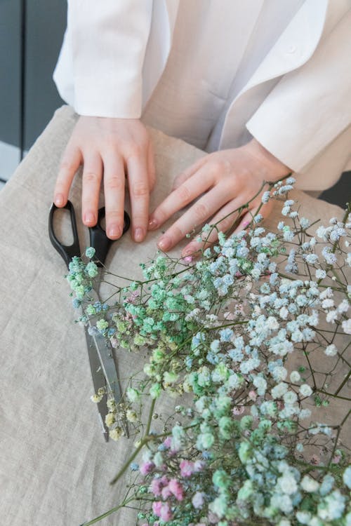 Ritaglia La Donna Al Tavolo Con Fiori E Forbici