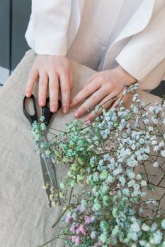 一位匿名女花商在桌旁为婚礼准备鲜花