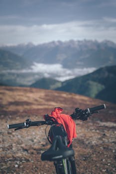 Mountain bike parked on rocky terrain with majestic mountains in the background.