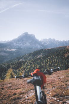 A mountain bike focuses on an expansive view of rugged mountains under a clear sky.