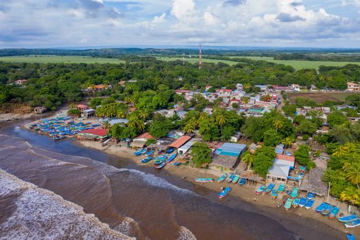 Scenic aerial view of a vibrant coastal town in Nicaragua with colorful boats and lush greenery.