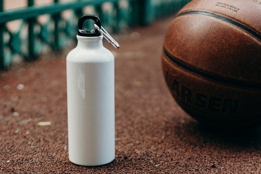 White water bottle and basketball on outdoor sports court.