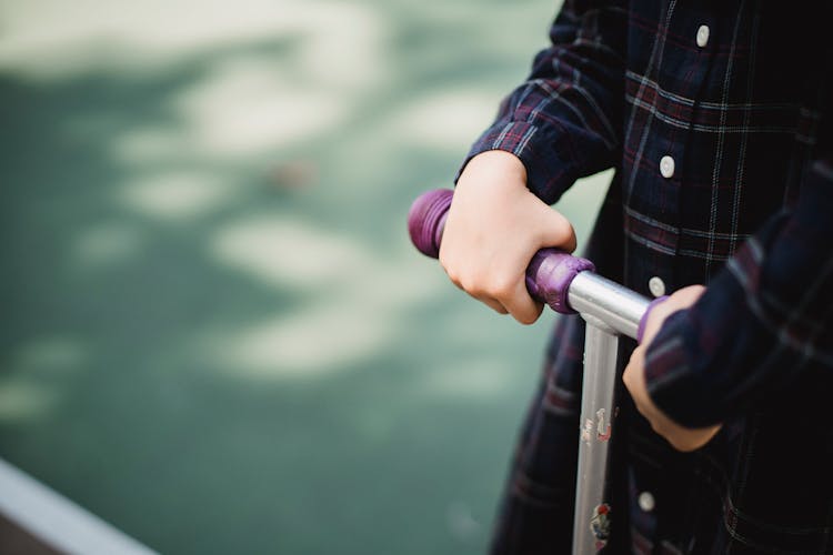 Girl Holding Hands On Bars Of Scooter