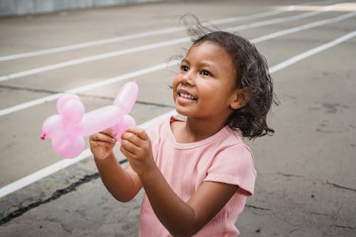 Girl in Pink Shirt Holding an Animal Balloon