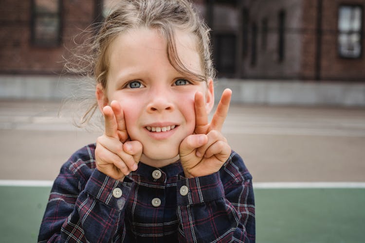 A Cute Little Girl Making Peace Sign