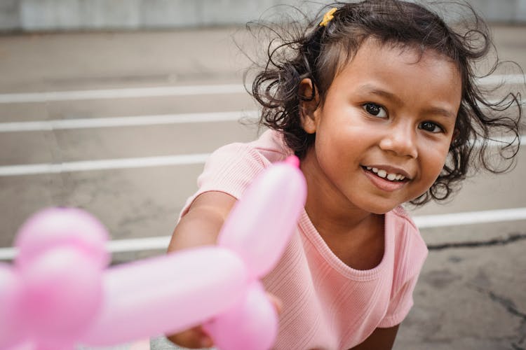 Girl Holding A Pink Balloon Twisting