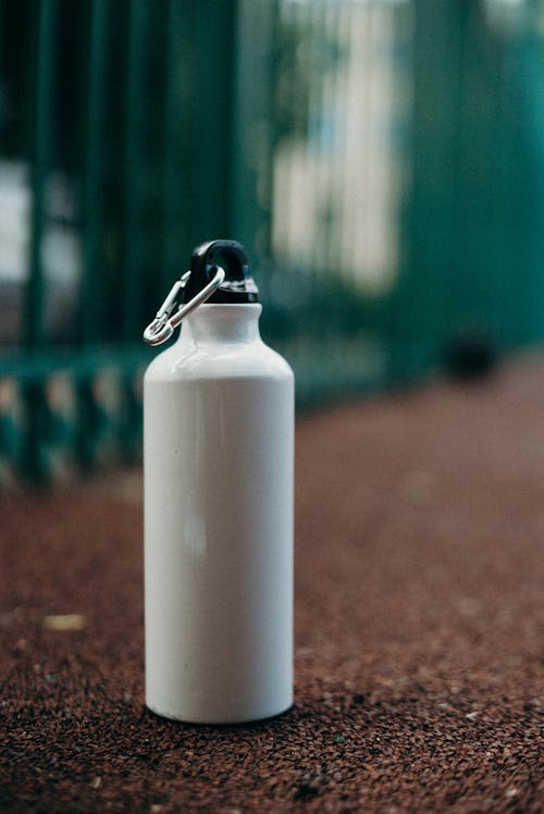 White Stainless Water Bottle on the Brown ground