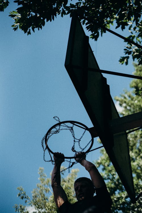 Man Dunking Holding Basketball Ring 
