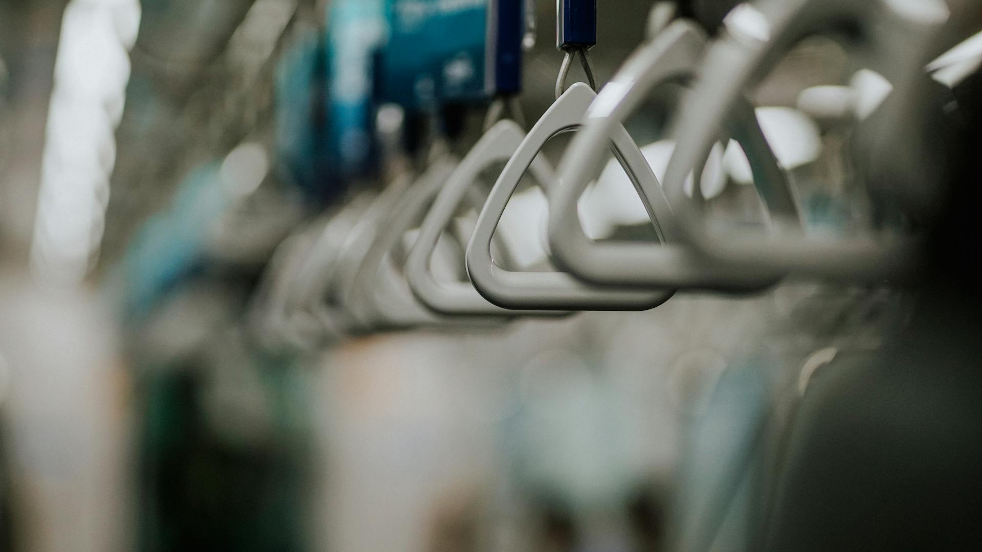 Blurred close-up photograph of train grab handles in Jakarta's railway system.
