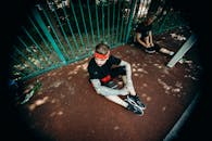 Two Men Sitting on Concrete Ground