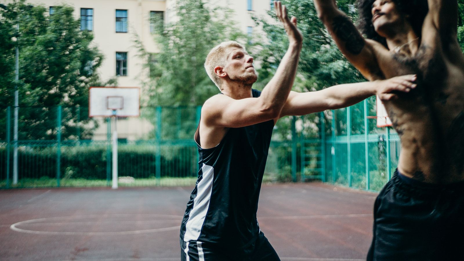 Representative licensed photograph of two men playing basketball on an outdoor court; not Anthony Edwards or a Minnesota Timberwolves game