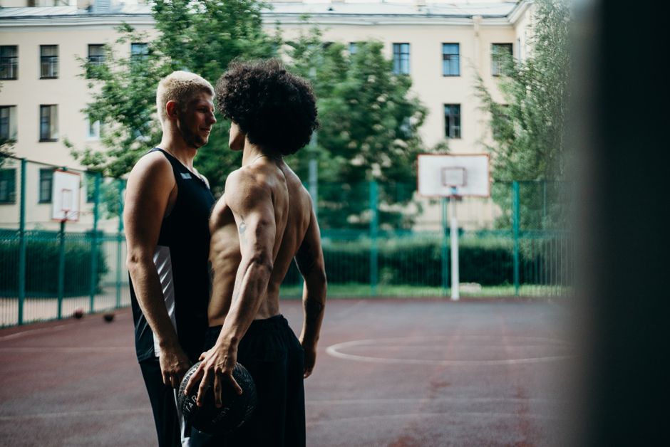 Former NBA player Enes Kanter Freedom speaking on sideline during a basketball game