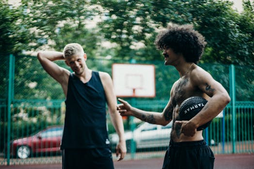 Two friends enjoying a basketball game on an outdoor court.