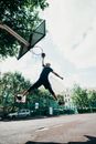 一名技术精湛的球员在户外球场的晴朗天空下完成扣篮