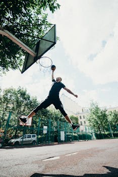 一名技术精湛的球员在户外球场的晴朗天空下完成扣篮