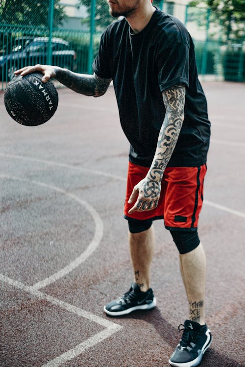 Man in Black Shirt Holding Black Basketball