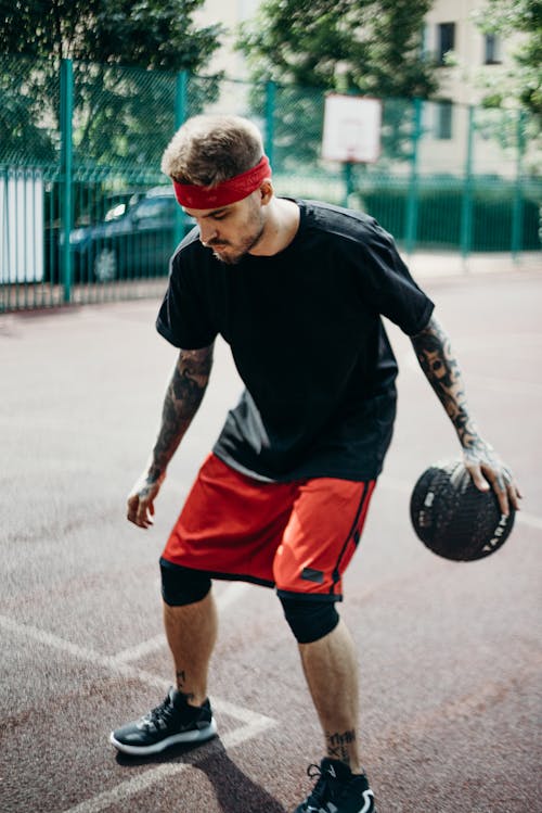 Man in Black Crew Neck T-shirt and Red Shorts Playing Basketball