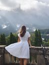 Back View of a Woman in White Dress Standing by the Balcony