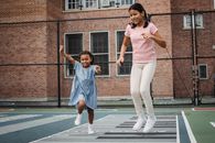 2 Women in Blue Polo Shirt and White Pants Running on Track Field