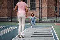 Woman in Pink Shirt and White Pants Standing Beside Boy in Blue Shirt