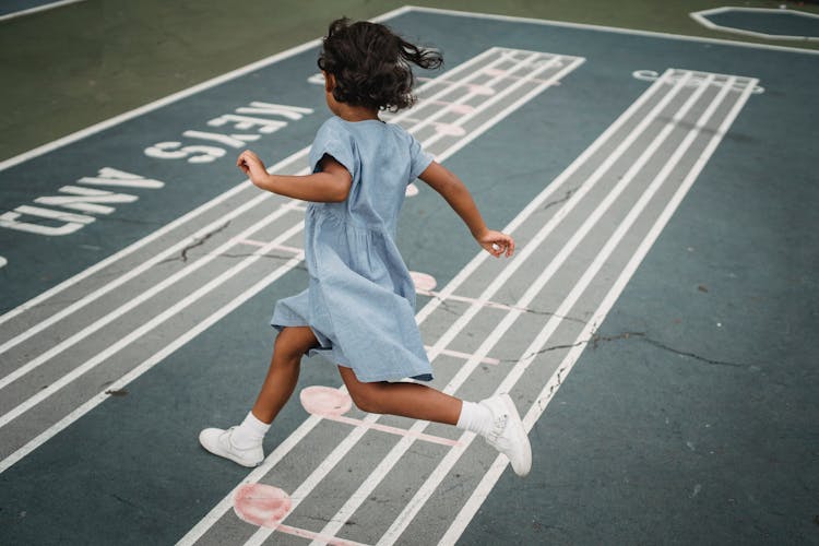 Girl In White Snickers Running On A Playground Over Treble Stuff