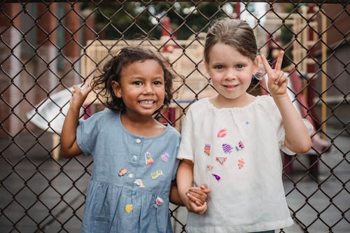 Little Girls Smiling and Showing a Peace Sign 