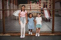 Girl in Blue Dress Standing Beside Girl in Pink Shirt