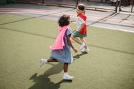 2 Girls in Pink and Blue Dress Running on Track Field