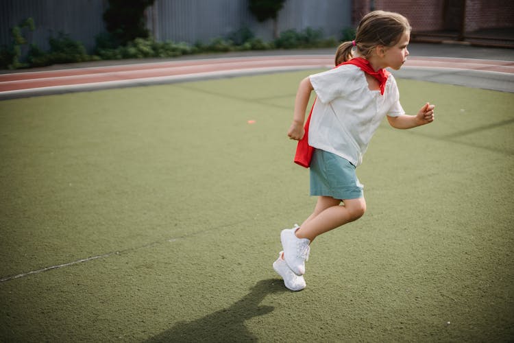 Little Girl Wearing A Superhero Cape Running 